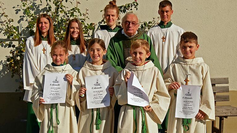 Augustinerpater Edmund Popp verabschiedete Ministrantinnen und Ministranten in Rieden und führte neue ein. Hinten von links sind die „alten“ Minis Luisa Krebs, Lina Schneider, Elias Königer und Lukas Beck in den bisherigen „Ministrantenkutten“. Vorne von links sind die neuen Minis in den neuen Alben: Greta Kaiser, Karla Pfeuffer, Joel Drehling und Simon Kaiser.