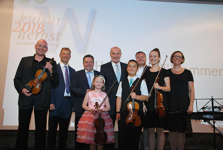 Eröffneten den Kulturherbst: (von links) Geigenvirtuose Florian Meierott, Gastgeber Wolfgang Roth, Zweiter Bürgermeister Rottendorf Klaus Hofstätter, Solistin Aspasia Kreier, Landrat Eberhard Nuß, Solist Linus Koeth, Geschäftsführer Wöllrieder Hof Oliver Ponnath, Solistin Merle Koeth und am Klavier Kathrin Koeth. Foto: Ammon