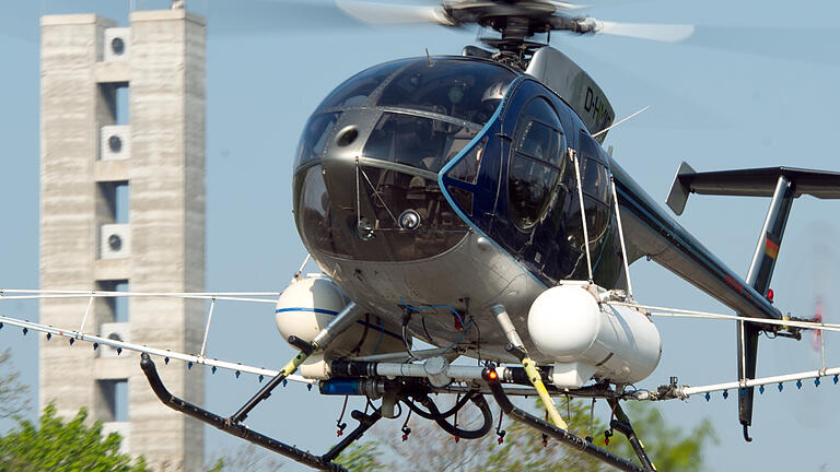 Mit dem Hubschrauber gegen Insekten       -  Ein Hubschrauber, der mit Sprüharmen ausgestattet ist, versprüht über dem Stadtwald von Frankfurt am Main (Hessen) ein Mittel gegen den Eichen-Prozessionsspinner. Die Tiere können bei Menschen Allergien auslösen. Das aus dem Helikopter versprühte Mittel soll für Menschen ungefährlich sein.