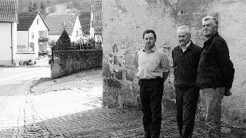Auf dem Platz vor der       -  Auf dem Platz vor der Scheune, auf dem Ortssprecher Richard Mahr und die Zeitzeugen Willi Kohles und Willi
Hack (von links) stehen, spielte vor 60 Jahren ein knapp dreijähriger Bub im Sand. Er wurde vermutlich von
Geschossen aus den Bordwaffen der amerikanischen Tiefflieger tödlich getroffen.