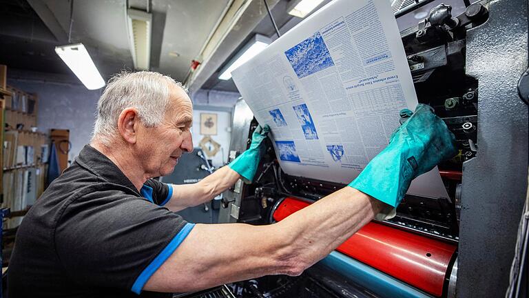 Volker Gunzenheimer legt eine Druckplatte in die Druckmaschine ein.