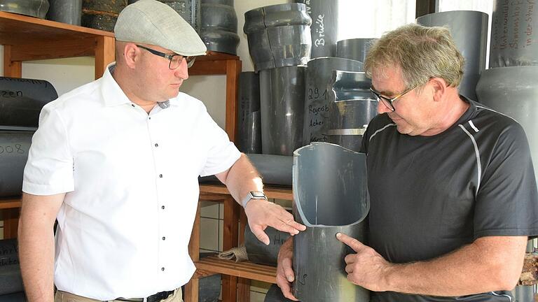 Bürgermeister Tobias Seufert (links) und Bauhofleiter Roland Ortloff nehmen eine gebrochene Leitung in Augenschein.