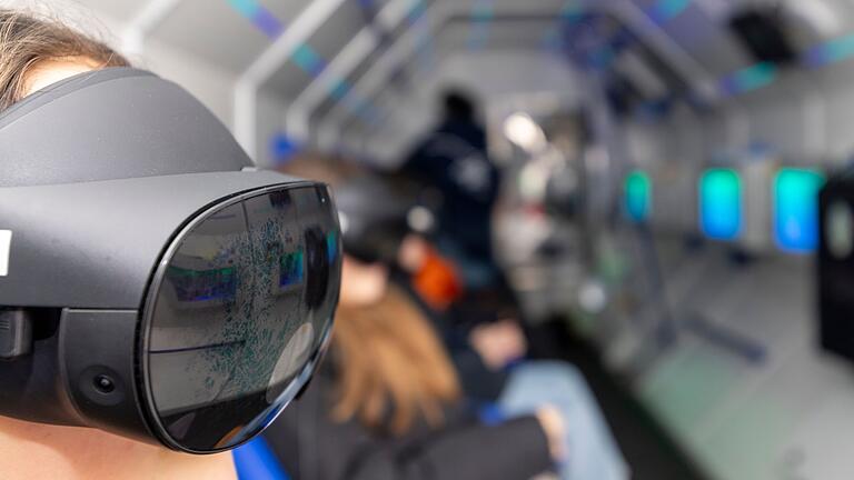 Die VR-Brillen, die die Schülerinnen und Schüler tragen, vermitteln das Gefühl, dreidimensional an Bord eines Raumfahrzeugs durchs Weltall zu fliegen.