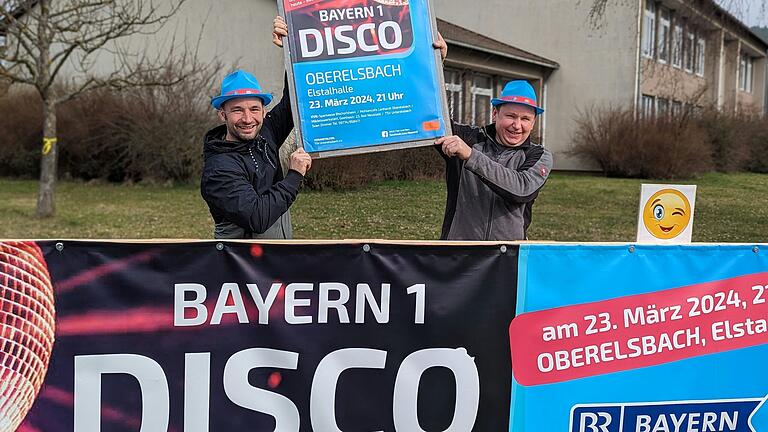 Die Bayern 1-Disco kommt in die Marktgemeinde Oberelsbach: Der Vorsitzende des TSV Unterelsbach, Thomas Englert (links), sowie Initiator und Organisator Sven Zimmer (rechts) freuen sich auf einen abwechslungsreichen Abend.