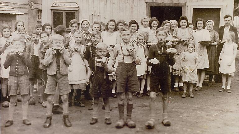 Historische Aufnahme: Eine Tradition in Ginolfs war es, dass zum Anlass einer Hochzeit im Backhaus Ploatz gebacken wurde. Jedes Kind, das sich in der Dorfmitte einfand, erhielt dann ein Stückchen auf die Hand.