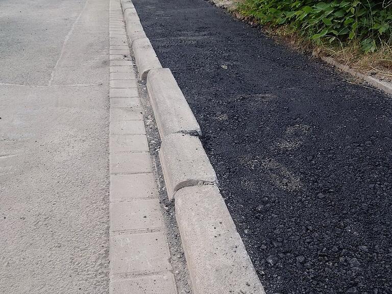 Zumindest fast gerade wurde dieser Gehsteigrand in Steinbach nach der Glasfaserverlegung.