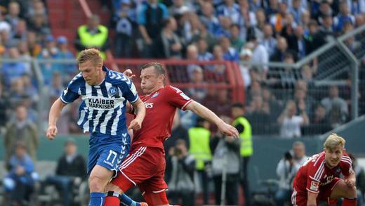 Attacke       -  Karlsruhes Rouwen Hennings (l) wird von Ivica Olic hart angegangen. Foto: Daniel Naupold