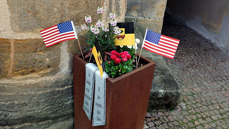 Die Gedenkschale mit Fähnchen der Stadt Ebern und der amerikanischen Flagge zum Zeichen der Erinnerung.