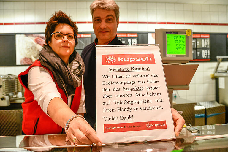 Die Inhaber Sabine und Christian Riedmayer vom Kupsch Markt in der Brettreichstraße im Würzburger Frauenland haben ihre Kunden auf Schildern an der Brot und Wursttheke gebeten, auf die Handynutzung zu verzichten.