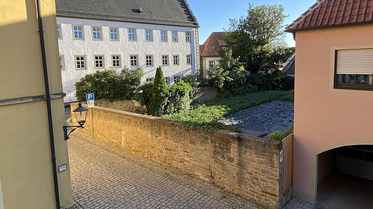 Die Stadt Gerolzhofen hat vor, in dem ehemals verpachteten Garten zwischen dem Gebäude der Verwaltungsgemeinschaft (links hinten im Bild) und dem Anwesen Brunnengasse 3 (rechts) elf Parkplätze zu errichten. Diese sollen entlang der Mauer Richtung VG-Gebäude entstehen. Die historische Sandsteinmauer zur Weiße-Turm-Straße hin (Mitte) würde für eine Zufahrt durchbrochen, an der Engstelle zum VG-Nebengebäude (links vorne). Die Stadt Gerolzhofen hat vor, in dem ehemals verpachteten Garten zwischen dem Gebäude der Verwaltungsgemeinschaft (links hinten im Bild) und dem Anwesen Brunnengasse 3 (rechts) elf Parkplätze zu errichten. Diese sollen entlang der Mauer Richtung VG-Gebäude entstehen. Die historische Sandsteinmauer zur Weiße-Turm-Straße hin (Mitte) würde für eine Zufahrt durchbrochen, an der Engstelle zum VG-Nebengebäude (links vorne). 