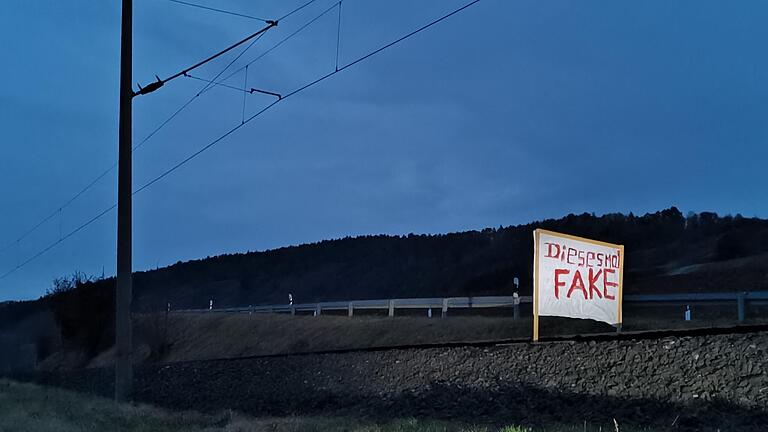 Fünf solcher Plakate wurden an Dreikönig 2021 auf den Gleisen der Werntalbahn zwischen Thüngen und Eußenheim (Lkr. Main-Spessart) aufgestellt. In eines davon fuhr ein umgeleiteter ICE.