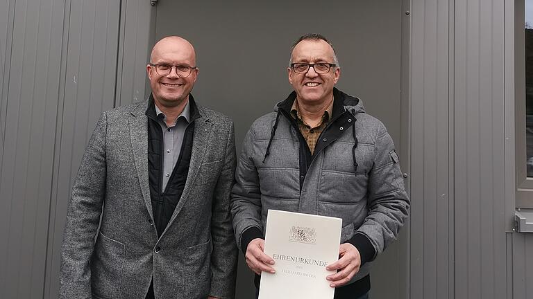 Das Foto zeigt Bürgermeister Volker Hemrich (links) zusammen mit Reinhold Greß vor dem Bauhof-Gebäude.