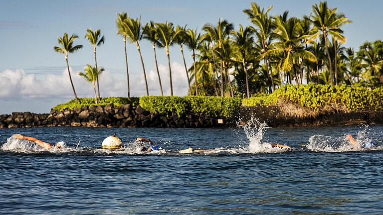 Beim Ironman-Triathlon-Wettbewerb auf Hawaii sind die Teilnehmer und Teilnehmerinnen im offenen Meer unterwegs. Beim Ironman-Triathlon-Wettbewerb auf Hawaii sind die Teilnehmer und Teilnehmerinnen im offenen Meer unterwegs.