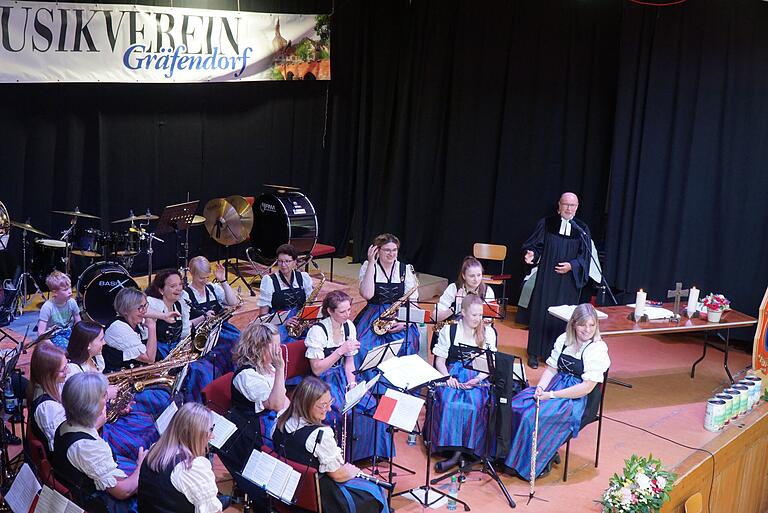 Pfarrer Thomas Schweizer bei seiner Predigt mit den Eschenbacher Musikanten auf der Bühne