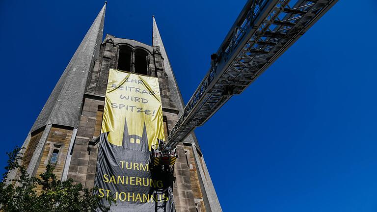 An der evangelischen St.Johanniskirche wird ein Plakat angebracht, um auf die Spendenaktion der Gemeinde aufmerksam zu machen. Es müssen 375000€ gesammelt werden für die Sanierung der Seitentürme.