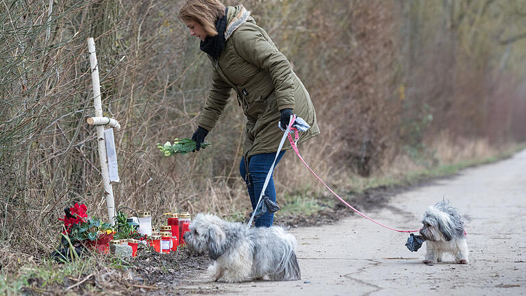 Eine Frau legt am Montag (08.01.18) Blumen am Unfallort nieder.