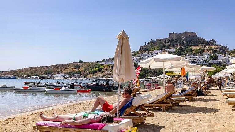 Touristen auf Rhodos.jpeg       -  Millionen von Deutschen können sich keinen Urlaub leisten. Damit fällt auch das Entspannen am Strand für viele weg.