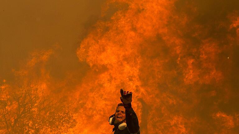 Klimawandel.jpeg       -  Ein Feuerwehrmann kämpft in dem Dorf in der Nähe von Athen gegen einen Waldbrand. Die Vereinten Nationen fürchten durch den Klimawandel eine Zunahme von Katastrophen mit schweren Auswirkungen auf Landwirtschaft und Ernährungssicherheit.