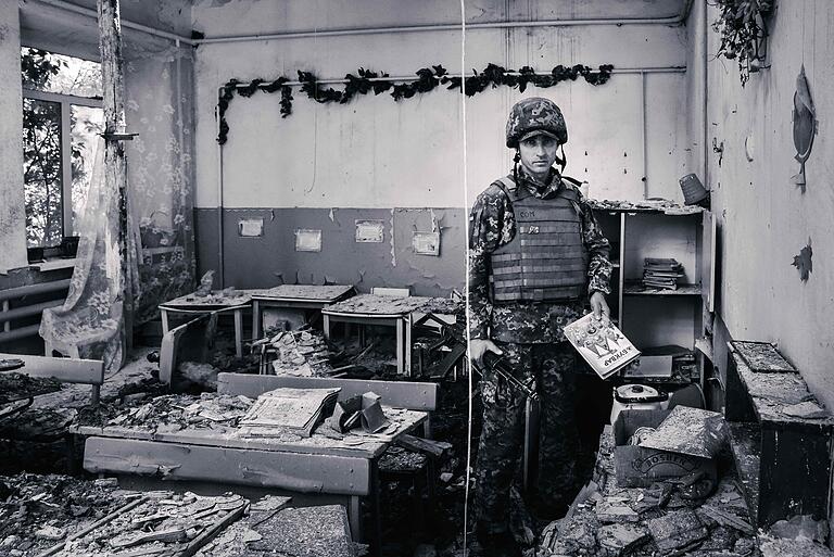 Donbas in der Ukraine, im Sommer 2019: Ein Soldat mit einem Bilderbuch in einem zerstörten Vorschulklassenzimmer in Shyrokyne. Der Küstenort war durch Kämpfe weitgehend zerstört worden.