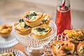 Amuse-Gueules sind auf einer Etagere angerichtet       -  Eine Idee für einen Happen vorab: Quiche im Miniformat - zum Beispiel gefüllt mit Ei, Feta und Spinat.