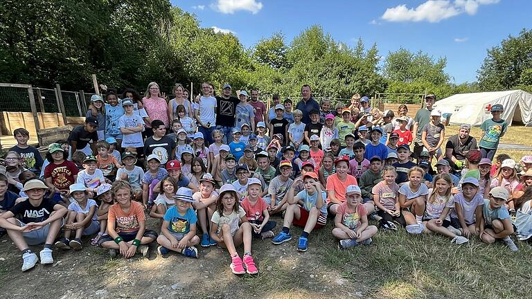 Präsentierten sich mit den Kindern zur Eröffnung des Ferienspielplatzes (hinten von links): Judith Schieblon, Dany Brazier mit ihrem Team Nicolas Frank, Aron Odenwald, René Ziegler, Charlotte Gottschaft, Peter Wirsching, Sina Friedrich und Bürgermeister Peter Juks.