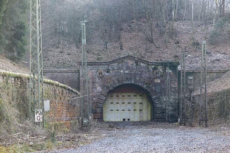  Blick auf das Portal des stillgelegten Schwarzkopftunnels in Heigenbrücken: Der 970 Meter lange alte Eisenbahntunnel zwischen den Bahnhöfen Laufach und Heigenbrücken wurde nach dem Neubau der Spessartrampe mit dem Falkenbergtunnel 2017 außer Betrieb genommen und verfüllt. Blick auf das Portal des stillgelegten Schwarzkopftunnels in Heigenbrücken: Der 970 Meter lange alte Eisenbahntunnel zwischen den Bahnhöfen Laufach und Heigenbrücken wurde nach dem Neubau der Spessartrampe mit dem Falkenbergtunnel 2017 außer Betrieb genommen und verfüllt.