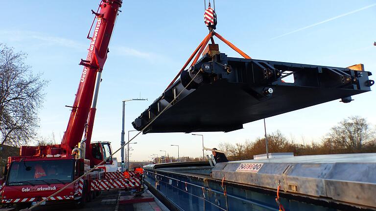 Für die Schleusenrevision wurde die Schifffahrt auf dem Main komplett gesperrt. Ein Autokran hebt den 32 Tonnen schweren Flügel eines Schleusentores aus dem Schiffsbauch eines Frachters.