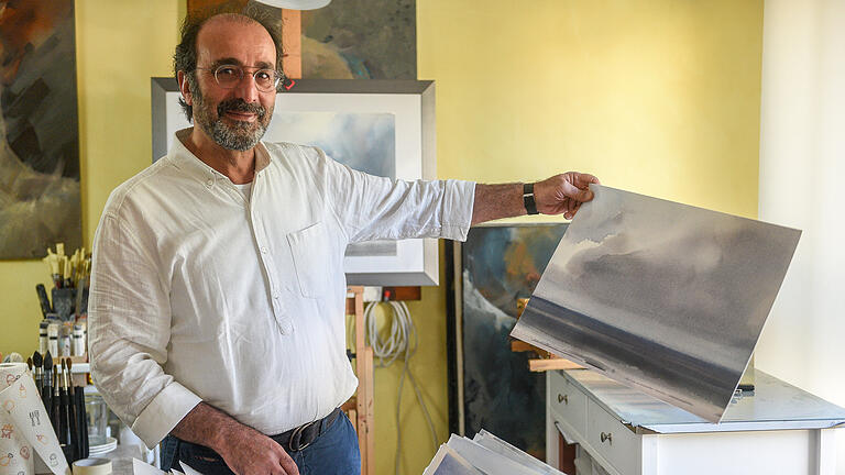 Maneis Arbab der Maler und Karikaturist aus Teheran hat Bilder von Nordsee-Landschaften gemalt. Hier zeigt er sie in seinem Atelier in Höchberg. Foto: Thomas Obermeier