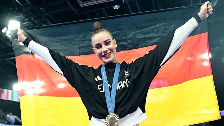 Paris 2024 - Rhythmische Sportgymnastik       -  Zeigt stolz die Goldmedaille und die deutsche Fahne: Darja Varfolomeev.