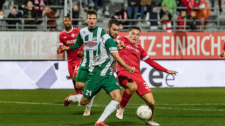 Tim Kraus (31) von den Würzburger Kickers im Zweikampf gegen Sebastian Raml (21) vom SV Schalding-Heining.Die Würzburger Kickers spielen am Dienstag Abend 17.10.23 gegen den SV Schalding-Heining in der AKON Arena 2:2.