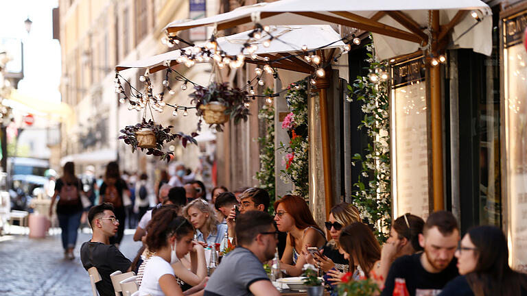 restaurant.jpeg       -  Touristen sitzen im Außenbereich eines Restaurants in der Via delle Muratte. In Rom hält der Tourismus nach und nach wieder Einkehr.