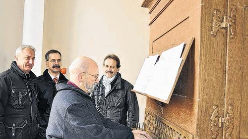 Organist Herbert Schmitt spielt erstmals nach der Restaurierung an der orgel in der Mellrichstädter Spitalkirche. Ihm schauen dabei Orgelbaumeister Herbert Hey (links), Stiftungsverwalter Peter Neuner (rechts) und dessen Stellvertreter Andreas Heim zu.