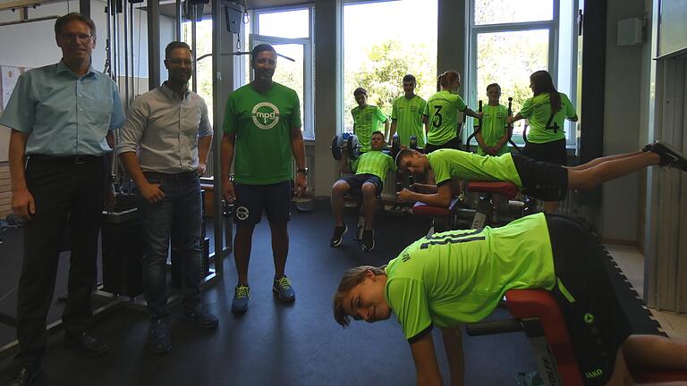 Nun hat das MPG auch einen Fitnessraum: Einige sportbegeisterte Schüler in ihren durch den Förderverein gesponserten adretten Trikots belagerten gleich die Geräte. Schulleiter Robert Jäger (links) und Fachbetreuer Michael Schmidt (rechts) dankten dem Vorsitzenden des Fördervereins, Christian Machon, für die Finanzierung der Geräte und der neuen Trikots.