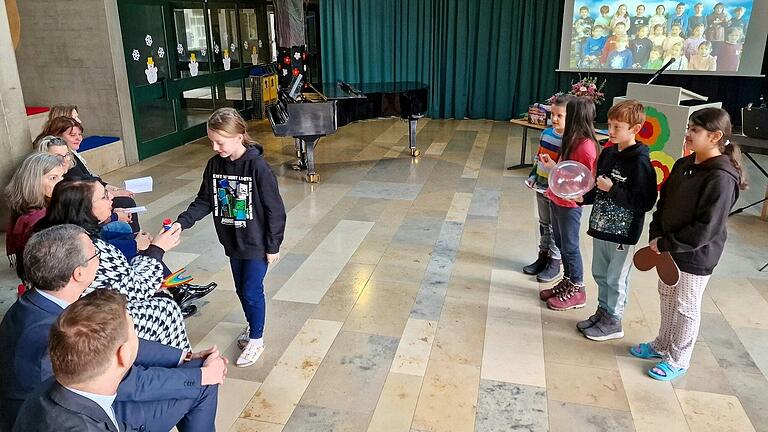 Alle Kinder der Grundschule übermittelten einen ganz lieben Willkommensgruß an die neue Chefin, im Hintergrund per Video eingeblendet, so auch das Lied 'Ich schenk dir einen Regenbogen' von der 2 c und übergab eine Abordnung von fünf Kinder aus der 4 b zum passenden Wort ein dazu passendes kleines Geschenk. Alle Kinder der Grundschule übermittelten einen ganz lieben Willkommensgruß an die neue Chefin, im Hintergrund per Video eingeblendet, so auch das Lied 'Ich schenk dir einen Regenbogen' von der 2 c und übergab eine Abordnung von fünf Kinder aus der 4 b zum passenden Wort ein dazu passendes kleines Geschenk.