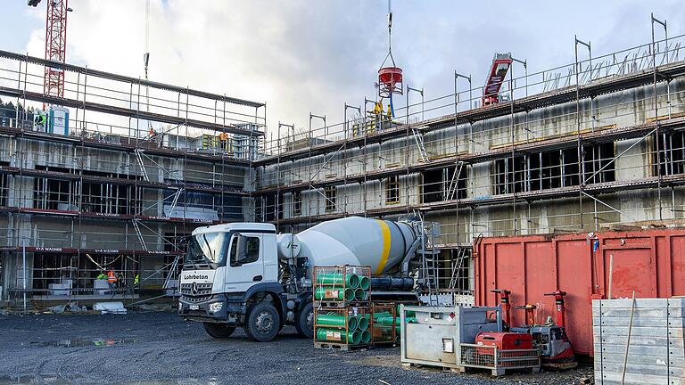 Ein Betonmischer liefert fertigen Beton an. Auch viele örtliche Firmen sind auf der Baustelle im Einsatz, beispielsweise für die Lieferung von Beton und Gerüst.