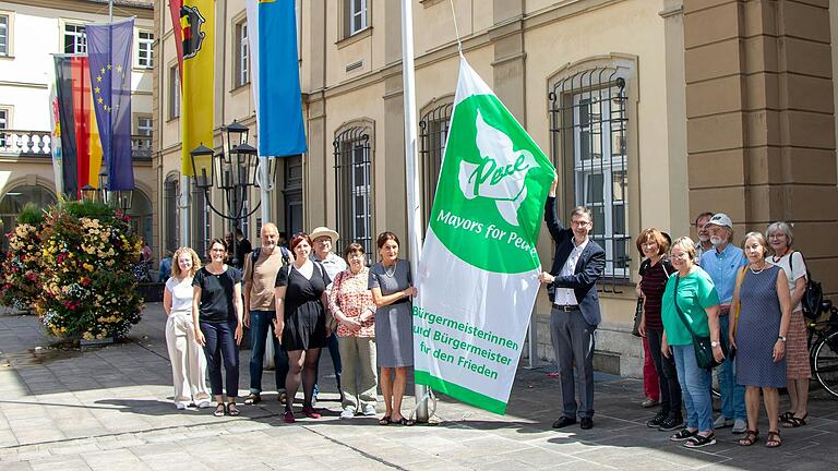 Stadträtin Barbara Meyer gemeinsam mit Oberbürgermeister Christian Schuchhardt (Mitte) beim Fahnenaufzug. Dabei unterstützten sie Mitglieder von Friedensorganisationen.