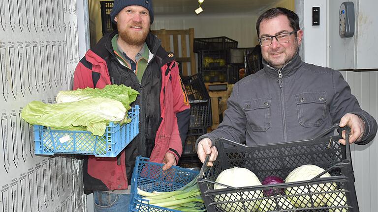 Im Kühlhaus werden die Salate und Gemüsesorten aufbewahrt, denen es draußen derzeit zu kalt ist. Einmal in der Woche werden die Körbe der SoLaWi-Anteilnehmer gefüllt und können abgeholt werden. Die beiden Gärtner Sascha Kirchner (links) und Til Brather bereiten dies vor.&nbsp;