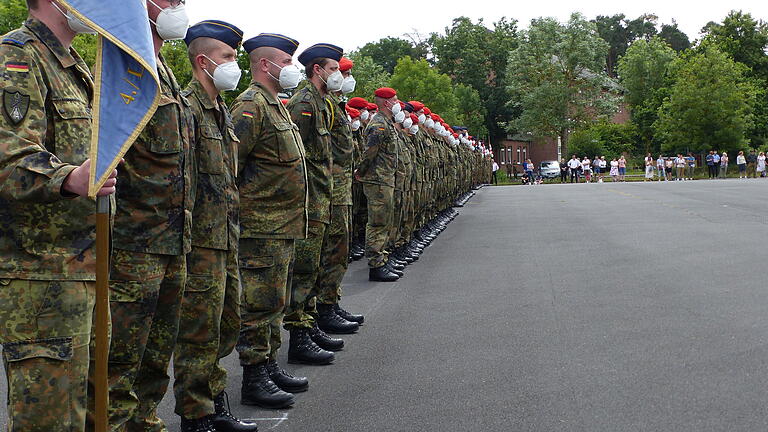Die jungen Rekruten sind in Reih und Glied angetreten. Rechts im Hintergrund ihre Familienangehörigen. Die jungen Rekruten sind in Reih und Glied angetreten. Rechts im Hintergrund ihre Familienangehörigen.