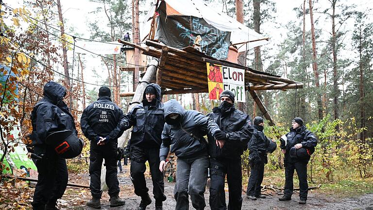 Polizei-Einsatz im Tesla-Protestcamp in Grünheide       -  Ein Aktivist wird von Polizisten aus dem Protestcamp in der Nähe des Tesla-Autowerks in Grünheide abgeführt.