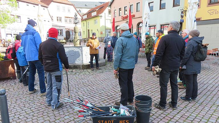 Ramadama in Bischofsheim ist eine gemeinsame Müllsammelaktion in allen Ortsteilen. Tobias Rehm (in der Mitte vor dem Brunnen) begrüßte die Helfer zur vom ihm initiierten Müllaktion, die in Bischofsheim sammelten. Er hatte vorher die verschiedenen Sammelbereiche eingeteilt und Übersichtskarten erstellt.