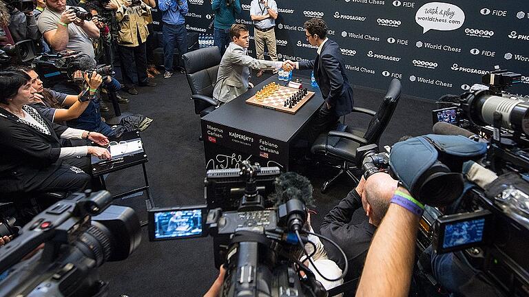 Schachweltmeisterschaft in London       -  Zwölf Mal gaben sich Schachweltmeister Magnus Carlsen (links am Tisch) und sein Herausforderer Fabiano Caruana vor Beginn des Spiels die Hand. Einen Sieger gab es erst später im Stechen.