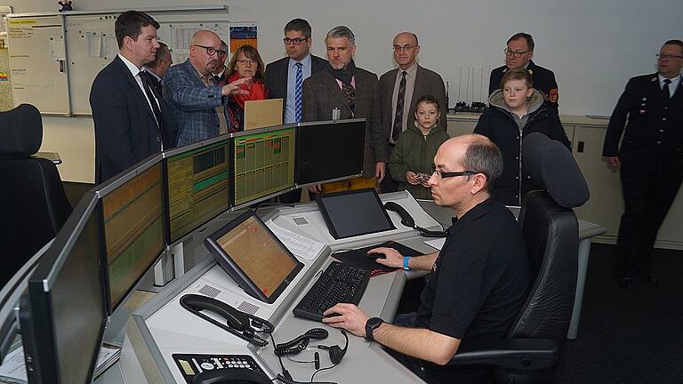 Stresstest für die Integrierte Leitstelle Schweinfurt: Am Übungs- und Ausbildungsplatz dürfen die geladenen Gäste Eindrücke der wirklichen Arbeit in einer integrierten Leitstelle verfolgen, und deren Leiter Thomas Schlereth (hellgraues Jacket) steht ihnen Rede und Antwort.