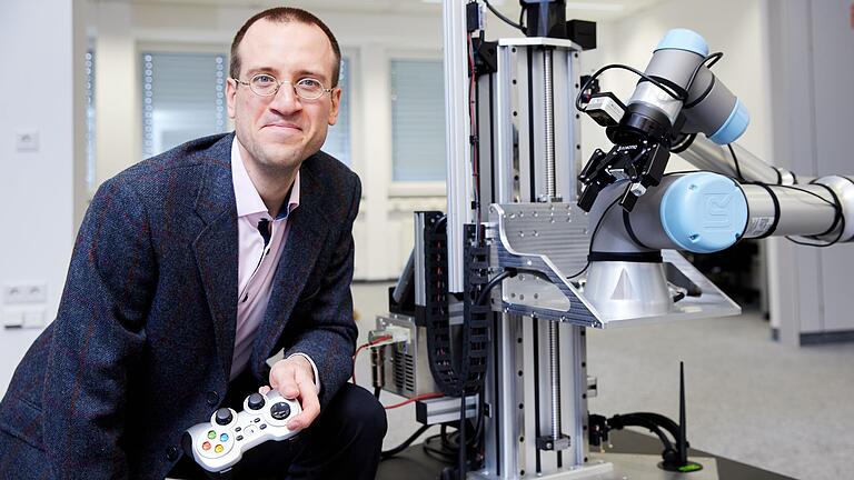 Einfach per Fernbedienung arbeiten lassen: Robotik-Professor Pascal Meißner ist davon überzeugt, dass solche als Cobots bezeichneten Kleinroboter gerade im Handwerk gute Dienste leisten können. Das Bild zeigt Meißner im Forschungszentrum Cairo in Würzburg.