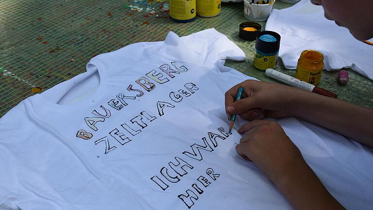 Eine Freizeit im Zeltlager auf dem Bauersberg, das hat für viele&nbsp; Schweinfurter generationenübergreifend Kultstatus. 2018, als dieses Bild entstand, malten sich die Kinder selbst Erinnerungs-T-Shirts. Für 2022 sind die vom Stadtjugendring organisierten Freizeiten noch gesichert.&nbsp; &nbsp;