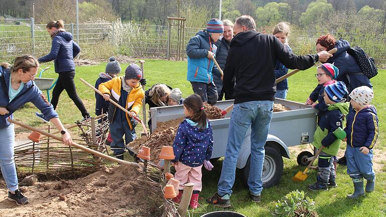 Eltern und Kinder schaufelten frische Erde in den Natur- und Insektenbereich.       -  Eltern und Kinder schaufelten frische Erde in den Natur- und Insektenbereich.