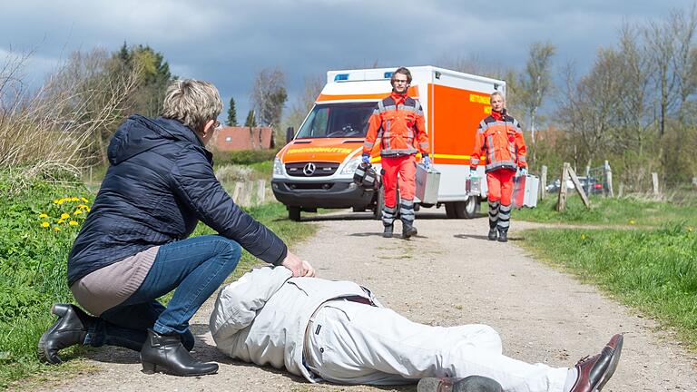 Eine Frau wartet auf einen Rettungswagen - In Notfällen ist jede Hilfe wichtig, da Nichtstun strafbar ist. Eine Frau wartet auf einen Rettungswagen - In Notfällen ist jede Hilfe wichtig, da Nichtstun strafbar ist.
