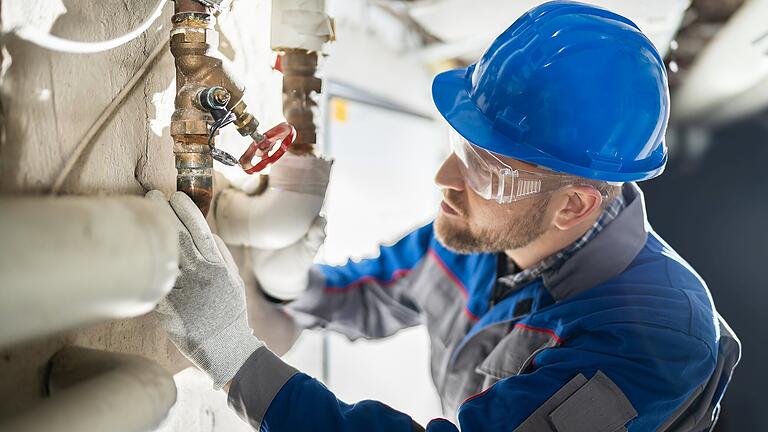 Male Worker Inspecting Valve - Male Worker Inspecting Water Valve For Leaks In Basement Male Worker Inspecting Valve - Male Worker Inspecting Water Valve For Leaks In Basement