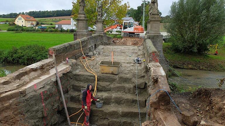 Mittlerweile ist die steinerne Unterkonstruktion der Barockbrücke in Frickendorf komplett freigelegt. Ein Mitarbeiter der Baufirma verfugt die Gewölbesteine mit Trass-Zement. Mittlerweile ist die steinerne Unterkonstruktion der Barockbrücke in Frickendorf komplett freigelegt. Ein Mitarbeiter der Baufirma verfugt die Gewölbesteine mit Trass-Zement.