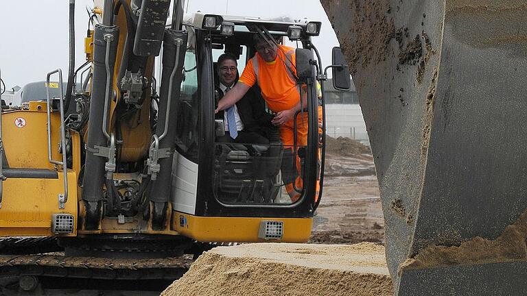 Firmenchef Mathias Kunert hatte offensichtlich großen Spaß, als er beim Spatenstich für das neue Hochregallager ans Steuer eines Baggers durfte. Foto: Hubert Herbert