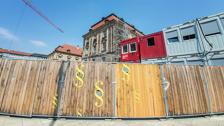 Einblicke in die Baustelle gibt es durch den Zaun immer da, wo sich das Paragrafen-Zeichen als Symbol der Justiz zeigt.